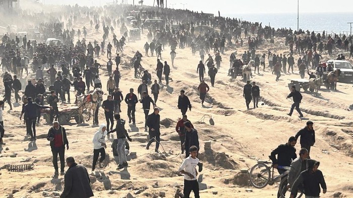Palestinians wait for humanitarian aid on a beachfront in Gaza City, Gaza Strip, Sunday, Feb. 25, 2024. (AP Photo/Mahmoud Essa)