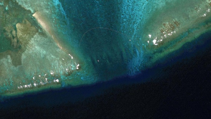 A Chinese Coast Guard vessel and a Philippine boat are seen near the entrance of Scarborough Shoal in the South China Sea, February 22, 2024. Maxar Technologies/Handout via REUTERS    THIS IMAGE HAS BEEN SUPPLIED BY A THIRD PARTY. NO RESALES. NO ARCHIVES. MANDATORY CREDIT. MUST NOT OBSCURE LOGO