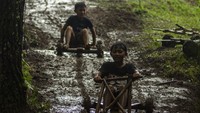 Anak-anak mengemudi permainan tradisional balap Kadaplak di Kampung Pasir Angling, Kabupaten Bandung Barat, Senin (26/2/2024).
