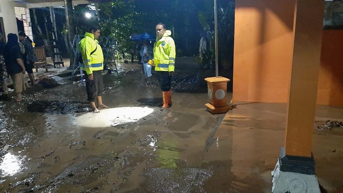 Polisi membantu membersihkan lumpur sisa banjir Anak Bengawan Solo di Ngawi