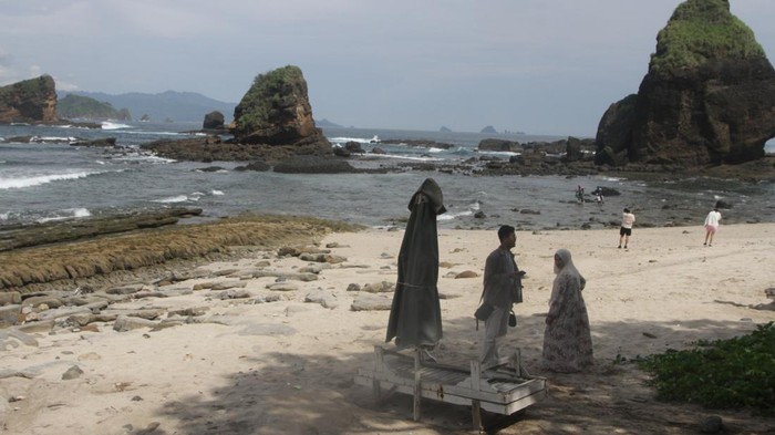 Wisatawan berekreasi di Pantai Pasir Putih Malikan (Papuma), Wuluhan,Jember, Jawa Timur, Senin (26/2/2024). Pemerintah setempat berkolaborasi dengan Perum Perhutani menggencarkan program pariwisata yakni membuka akses menuju destinasi wisata pantai baru serta melengkapi fasilitas di sejumlah pantai guna meningkatkan kunjungan wisatawan di kabupaten Jember yang pada akhir tahun 2023 mencapai 745.952 orang sehingga mendongkrak Pendapatan Asli Daerah (PAD). ANTARA FOTO/Ari Bowo Sucipto/Spt.