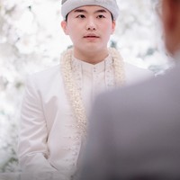 Park Younggwang tampil gagah mengenakan busana pengantin Palembang berwarna putih. Penampilannya itu juga dilengkapi dengan penutup kepala kopiah cuplak berwarna senada. Foto: Instagram/@rachellyahya/@bootesphotography