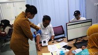 Petugas melakukan pengecekan tensi darah warga yang akan melakukan vaksinasi COVID-19.