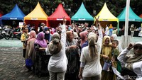 Petugas memberikan pengarahan kepada warga yang sedang mengantre beras murah.