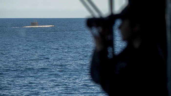 7 Negara NATO Gelar Latihan Militer Kapal Selam Terbesar An officer watches a submarine from aboard the Italian Navy Francesco Morosini offshore patrol vessel, off the coast of Catania, Sicily, southern Italy, Monday, Feb. 26, 2024. The Morosini is part of the NATO warfare exercise 'Dynamic Manta 24' that will take place off the eastern and southern coasts of Sicily where seven submarines will in turn hunt and be hunted, in close coordination with air and surface assets. (AP Photo/Salvatore Cavalli)