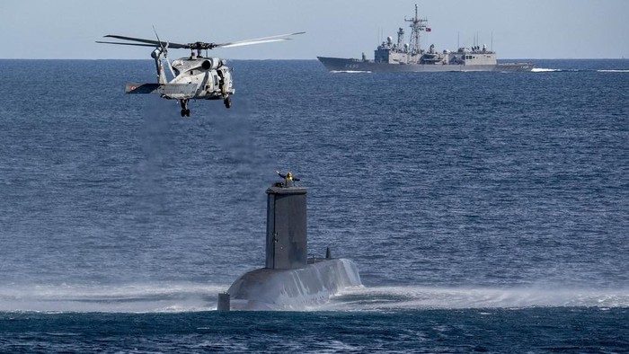 7 Negara NATO Gelar Latihan Militer Kapal Selam Terbesar An officer watches a submarine from aboard the Italian Navy Francesco Morosini offshore patrol vessel, off the coast of Catania, Sicily, southern Italy, Monday, Feb. 26, 2024. The Morosini is part of the NATO warfare exercise 'Dynamic Manta 24' that will take place off the eastern and southern coasts of Sicily where seven submarines will in turn hunt and be hunted, in close coordination with air and surface assets. (AP Photo/Salvatore Cavalli)
