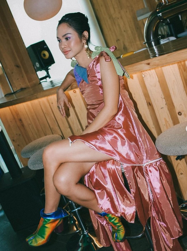 Di pemotretan tersebut Andien juga tampak mengenakan beberapa pakaian. Salah satunya dress berwarna salmon yang dipadukan dengan pita berwarna hijau dan biru di pundaknya. Foto: Instagram/@andienaisyah