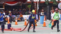 Seorang peserta melakukan keterampilan menggelar selang dan menggulung selang.