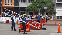 Saling adu cepat memasang tangga untuk penyelamatan korban kebakaran di atas gedung.