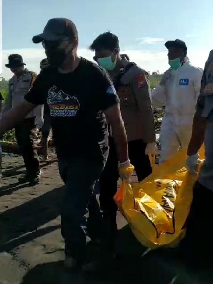 Petugas melakukan evakuasi temuan mayat berbaju kotak-kotak di Pantai Paseban Jember