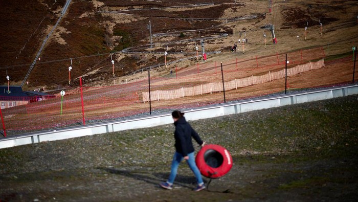 Skiers pass on an artificial ski snow slope on a mild winter day in the Bareges ski resort, Hautes-Pyrenees, southwestern France, February 21, 2024. REUTERS/Stephane Mahe