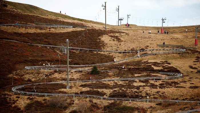 Skiers pass on an artificial ski snow slope on a mild winter day in the Bareges ski resort, Hautes-Pyrenees, southwestern France, February 21, 2024. REUTERS/Stephane Mahe