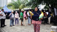 Seorang warga tersenyum usai membeli beras dalam program Aksi Amankan Harga Pangan di halaman Taman Ismail Marzuki, Jl Cikini Raya, Selasa (27/2/2024).