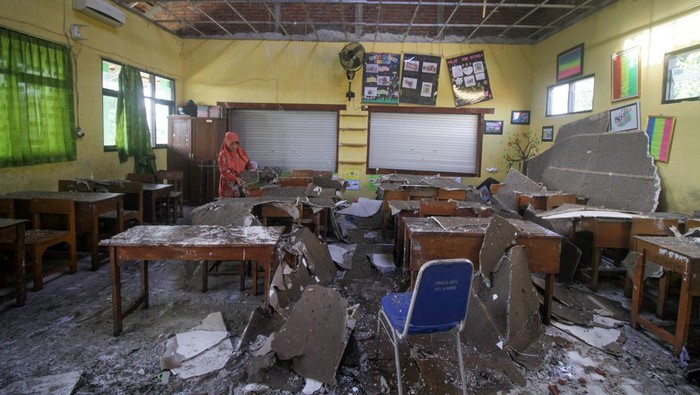 Guru membersihkan ruang kelas SDN Sumput yang rusak diterjang angin kencang di Sumput, Sidoarjo, Jawa Timur, Selasa (27/2/2024). Empat ruang kelas di sekolah itu rusak akibat hujan deras dan angin kencang pada Senin (26/2) sore. ANTARA FOTO/Umarul Faruq/nym.