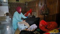 Warga yang terdampak tanah ambles tersebut, memindahkan barang-barang miliknya ke lokasi yang aman.