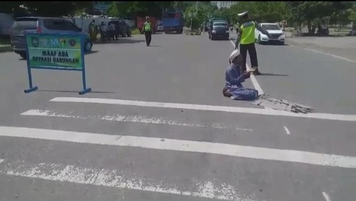 Seorang pria di Bima berdoa di tengah jalan gegara ditilang polisi, Selasa (27/2/2024).