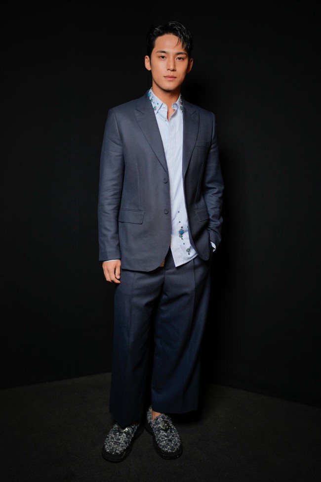 Kim Mingyu hadir di Paris Fashion Week dalam balutan koleksi busana pria Dior Spring/Summer 2024. Rapper bersuara merdu dari Seventeen itu tampil dalam balutan blazer dan celana biru yang dipadukan dengan kemeja bergaris putih dan biru muda. Foto: Swan Gallet/WWD via Getty Images