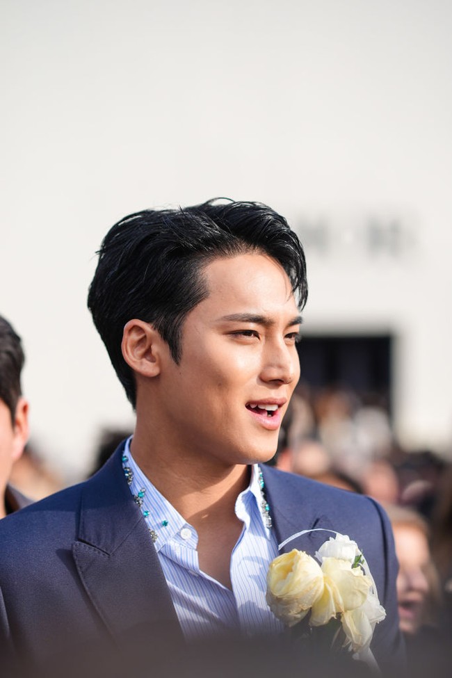 Kemeja Dior yang dipakai Mingyu Seventeen ini memiliki detail hiasan batu permata dan zamrud biru yang senada dengan blazer dan celananya. Foto: Getty Images/Edward Berthelot