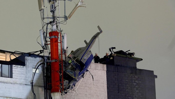 Penampakan Helikopter Jatuh di Kolombia Akibat Angin Kencang A helicopter hangs from the roof of a building after crashing due to strong winds, according to authorities, in Medellin, Colombia February 26, 2024. REUTERS/Juan David Duque NO RESALES. NO ARCHIVES TPX IMAGES OF THE DAY