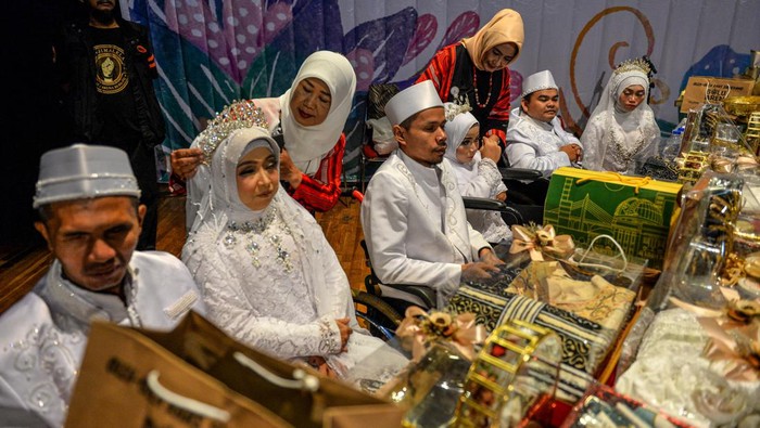 Petugas merias calon pengantin difabel saat nikah massal di Taman Budaya, Bandung, Jawa Barat, Rabu (28/2/2024). Mimbar Hiburan Amal dan Dhuafa (MHABD) menggelar pernikahan massal bagi warga disabilitas untuk ke-35 kali nya, serta memberikan santunan dalam rangka menyambut Bulan Suci Ramadhan. ANTARA FOTO/Raisan Al Farisi/nym.