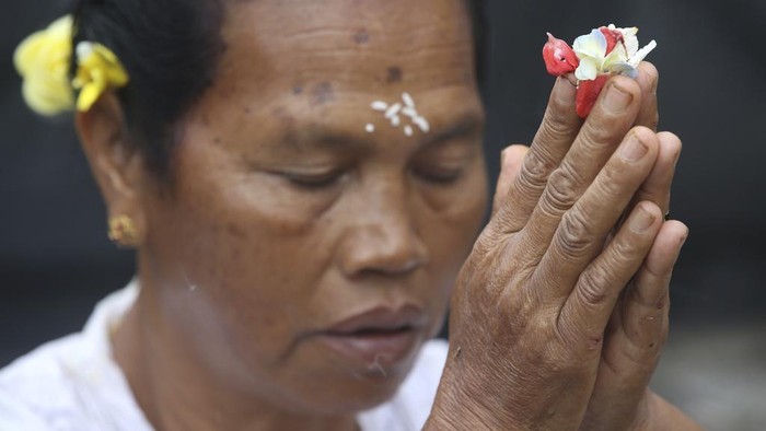 Hindu priest Ketut Simpen prays at a temple during Hindu festival of Galungan, the celebration of the triumph of good over evil at Penglipuran village, Bangli, Bali, Indonesia on Wednesday, Feb. 28, 2024. (AP Photo/Firdia Lisnawati)