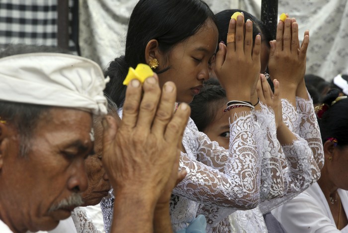 Hindu priest Ketut Simpen prays at a temple during Hindu festival of Galungan, the celebration of the triumph of good over evil at Penglipuran village, Bangli, Bali, Indonesia on Wednesday, Feb. 28, 2024. (AP Photo/Firdia Lisnawati)