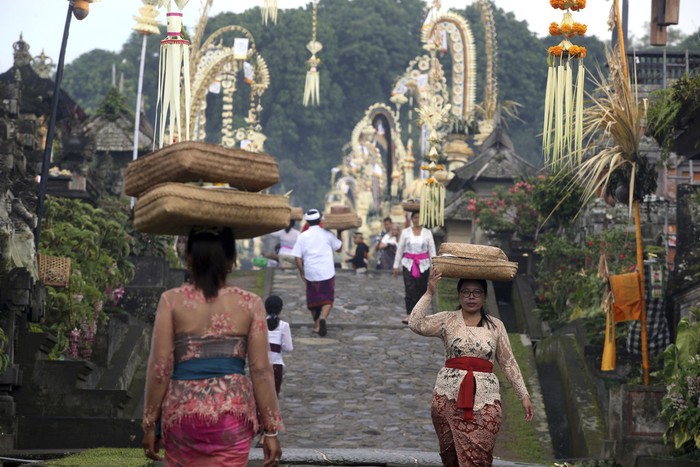 Hindu priest Ketut Simpen prays at a temple during Hindu festival of Galungan, the celebration of the triumph of good over evil at Penglipuran village, Bangli, Bali, Indonesia on Wednesday, Feb. 28, 2024. (AP Photo/Firdia Lisnawati)