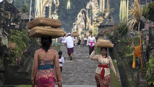 Hindu priest Ketut Simpen prays at a temple during Hindu festival of Galungan, the celebration of the triumph of good over evil at Penglipuran village, Bangli, Bali, Indonesia on Wednesday, Feb. 28, 2024. (AP Photo/Firdia Lisnawati)