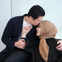 Di hari anniversary pernikahan keduanya tampil kompak dan mesra. Seperti yang terlihat dalam salah satu foto saat Reino mencium kening Syahrini dengan penuh cinta. Foto: Instagram/@princessyahrini