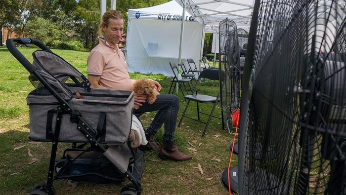 AUSTRALIA-WEATHER/HEAT-HOMELESSNESS Social housing resident, Adam Abbi, cools down with his dog Georgie in Australia's first mobile cooling hub, in Sydney, Australia, February 29, 2024. REUTERS/Cordelia Hsu