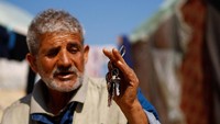 Mohammed Al-Majdalawi, seorang pengungsi Palestina yang rumahnya dihancurkan oleh serangan Israel memegang kunci rumahnya yang hancur, di luar tendanya di Rafah, di Jalur Gaza selatan, 26 Februari 2024.