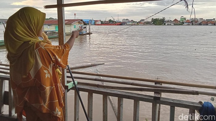 Lia, warga RT 34, Kelurahan 13 Ulu Palembang menunjuk arah datangnya buaya yang muncul pada Minggu (25/2/2024) sore.