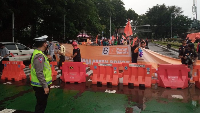 Massa buruh menggelar aksi unjuk rasa di kawasan Patung Kuda, Jakarta Pusat (Jakpus). Arus lalu lintas (lalin) yang mengarah ke Istana Negara dialihkan. (dok TMC Polda Metro Jaya)