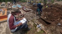 Petugas mendata makam yang dibongkar dan selanjutnya dipindah ke tempat yang baru di Beku, Karanganom, Klaten, Jawa Tengah, Kamis (29/2/2024).