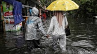Sejumlah warga tampak nekat menerobos jalan yang terendam banjir.