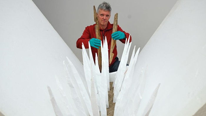 Penampakan Perangkap Mematikan dari Kayu Runcing Era Militer Romawi 26 February 2024, Rhineland-Palatinate, Mainz: Markus WittkΓΆpper, restorer of antiquities, presents sharpened wooden stakes from a Roman defense trench (1st century AD) behind a polystyrene model at the Leibniz Centre for Archaeology (LEIZA). The deadly traps made of sharpened wooden stakes were discovered during archaeological investigations of two Roman military camps in Bad Ems and examined, restored and conserved in the restoration laboratory in Mainz. Photo: Arne Dedert/dpa (Photo by Arne Dedert/picture alliance via Getty Images)
