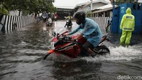 Banyak pekerja pabrik yang nekat menerobos banjir dengan motor. 