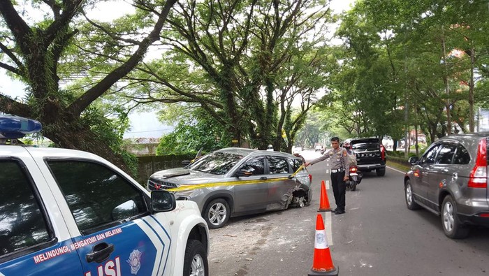 Polisi mengevakuasi mobil di Gowa yang menabrak pohon gegara hindari pemotor.