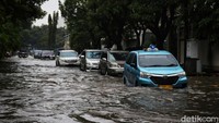 Mobil berjalan perlahan saat mencoba menerobos banjir.