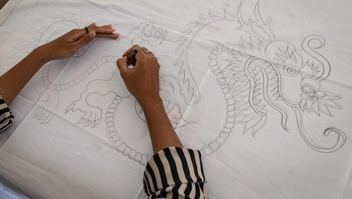 Pekerja menyelesaikan pembuatan pola batik tulis bermotif naga di rumah produksi batik tulis Kidang Mas Lasem di Desa Babagan, Kecamatan Lasem, Kabupaten Rembang, Jawa Tengah, Kamis (29/2/2024). Menurut data yang dihimpun lembaga pelestarian budaya Yayasan Lasem Heritage per tahun 2022, terdapat 78 unit rumah produksi batik aktif dengan jumlah pekerja 1.032 orang yang 92 persennya merupakan perempuan, dan diperkirakan akan terus bertambah seiring menggeliatnya perekonomian pasca pandemi COVID-19 tahun 2020 yang sempat mengalami penurunan penjualan. ANTARA FOTO/Aji Styawan/YU