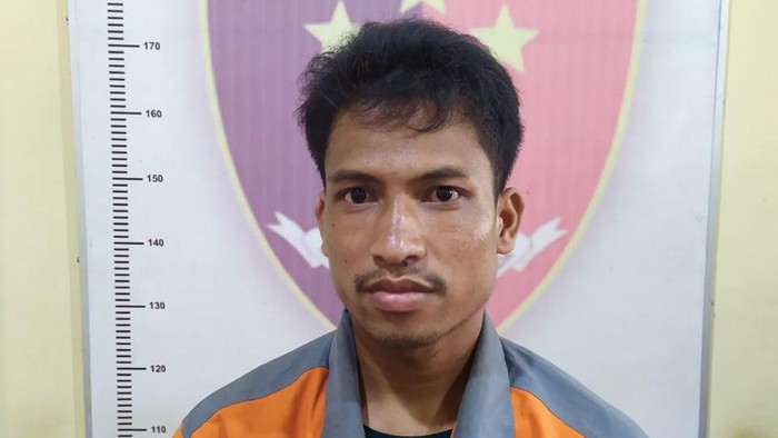 Tersangka saat diamankan di kantor polisi.