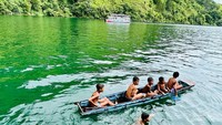 Bermain sampan di tebing batu gantung di Danau Toba.