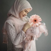 Bella tampil cantik dan bersahaja memakai dress panjang warna blush pink. Dress tampak mewah dengan aksen lace, bordir dan tulle. Sang buah hati pun mengenakan busana bertema senada. Foto: Instagram/@denny_caknan @bellabonita_r.a