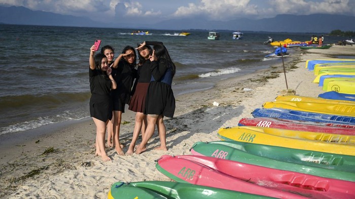 Wisatawan bermain air di Pantai Bulbul, Balige, Toba, Sumatera Utara, Kamis (29/2/2024). Pantai Bulbul merupakan salah satu daya tarik wisatawan untuk menikmati Destinasi Super Prioritas (DSP) Indonesia yang memilki keunikan dengan air tawarnya yang berasal dari Danau Toba dan pasir putih. ANTARA FOTO/Erlangga Bregas Prakoso/Spt.