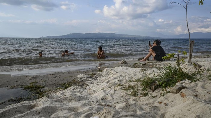 Wisatawan bermain air di Pantai Bulbul, Balige, Toba, Sumatera Utara, Kamis (29/2/2024). Pantai Bulbul merupakan salah satu daya tarik wisatawan untuk menikmati Destinasi Super Prioritas (DSP) Indonesia yang memilki keunikan dengan air tawarnya yang berasal dari Danau Toba dan pasir putih. ANTARA FOTO/Erlangga Bregas Prakoso/Spt.