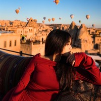 Fuji berpose dengan latar belakang pemandangan bangunan-bangunan di Cappadocia dan balon-balon udara. Foto: Instagram/@fuji_an