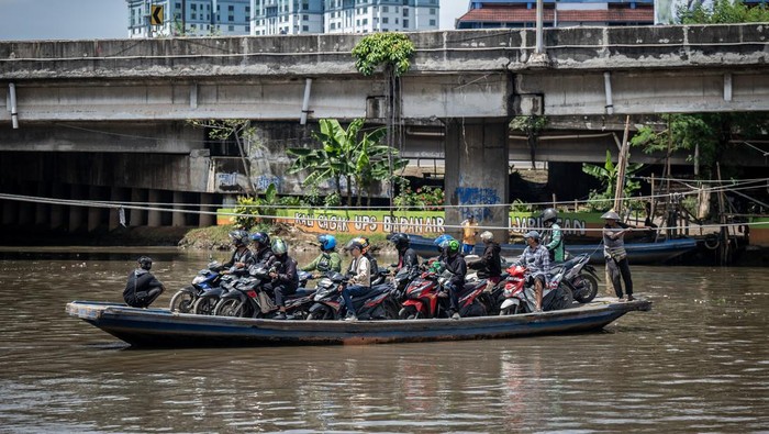 Jasa penyeberangan perahu eretan di Jakarta Sejumlah pengendara sepeda motor menggunakan perahu eretan menyeberangi Sungai Kali Angke di Kecamatan Penjaringan, Jakarta, Jumat (1/3/2024). Warga masih memanfaatkan jasa penyeberangan perahu eretan untuk memangkas jarak dan waktu ke tempat tujuan dengan tarif Rp2.000 untuk sekali jalan. ANTARA FOTO/Bayu Pratama S/tom.