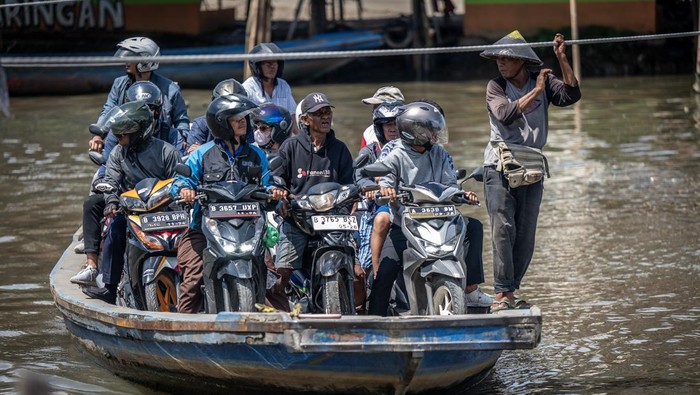 Jasa penyeberangan perahu eretan di Jakarta Sejumlah pengendara sepeda motor menggunakan perahu eretan menyeberangi Sungai Kali Angke di Kecamatan Penjaringan, Jakarta, Jumat (1/3/2024). Warga masih memanfaatkan jasa penyeberangan perahu eretan untuk memangkas jarak dan waktu ke tempat tujuan dengan tarif Rp2.000 untuk sekali jalan. ANTARA FOTO/Bayu Pratama S/tom.