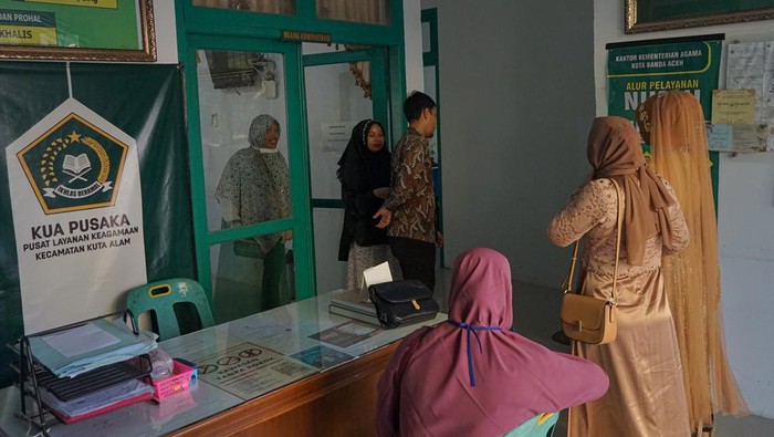 Kemenag Rencanakan 40 Layanan KUA untuk Semua Agama Petugas Kantor Urusan Agama (KUA) Kuta Alam melayani calon pengantin perempuan yang akan melaksanakan akad nikah di KUA Kuta Alam, Banda Aceh, Aceh, Jumat (1/3/2024). Kementerian Agama pada 2024 berencana melakukan transformasi KUA sebagai tempat yang melayani urusan semua agama, sehingga akan menjadi tempat menikah dan pencatatan pernikahan semua agama di Indonesia. ANTARA FOTO/Khalis Surry/rwa.