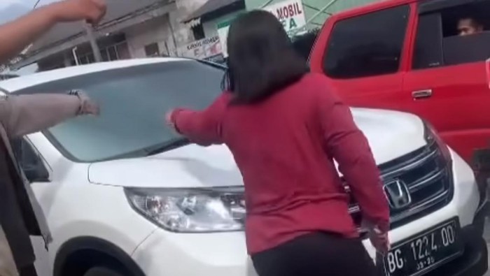 Pemotor wanita memarahi pengemudi mobil yang menyerempetnya.